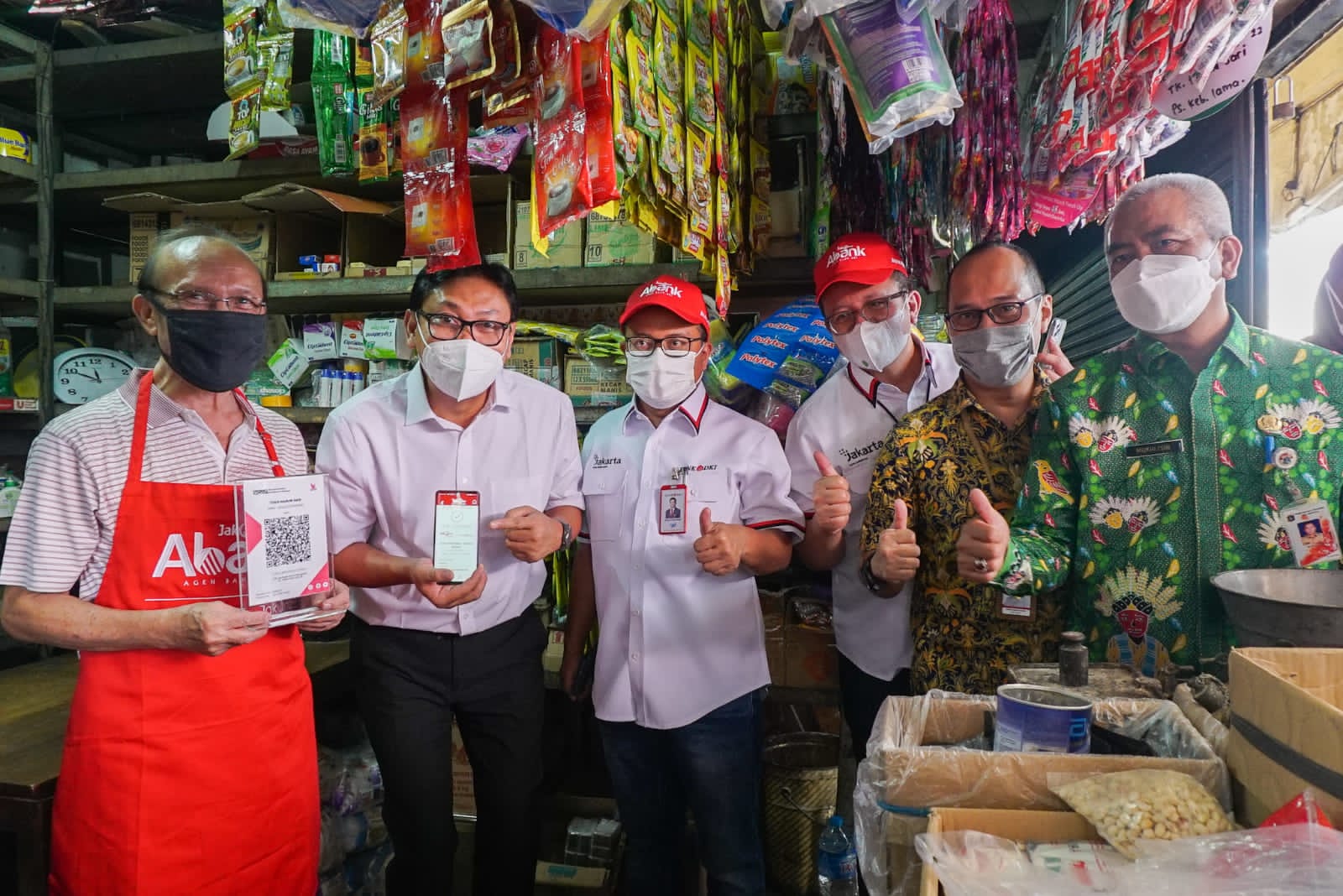 Kepala Perwakilan Bank Indonesia DKI Jakarta, Onny Widjanarko (kedua kiri) bersama Direktur Ritel & Syariah, Babay Parid Wazdi (ketiga kiri) usai bertransaksi menggunakan JakOne Mobile Bank DKI pada acara monitoring on site penerapan akseptasi pembayaran digital SIAP QRIS, di Pasar Kebayoran Lama, Kamis (11/8/2022). dok. ist. Melalui JakOne Mobile, Bank DKI Hadirkan Solusi Perbankan Digital bagi Nasabah