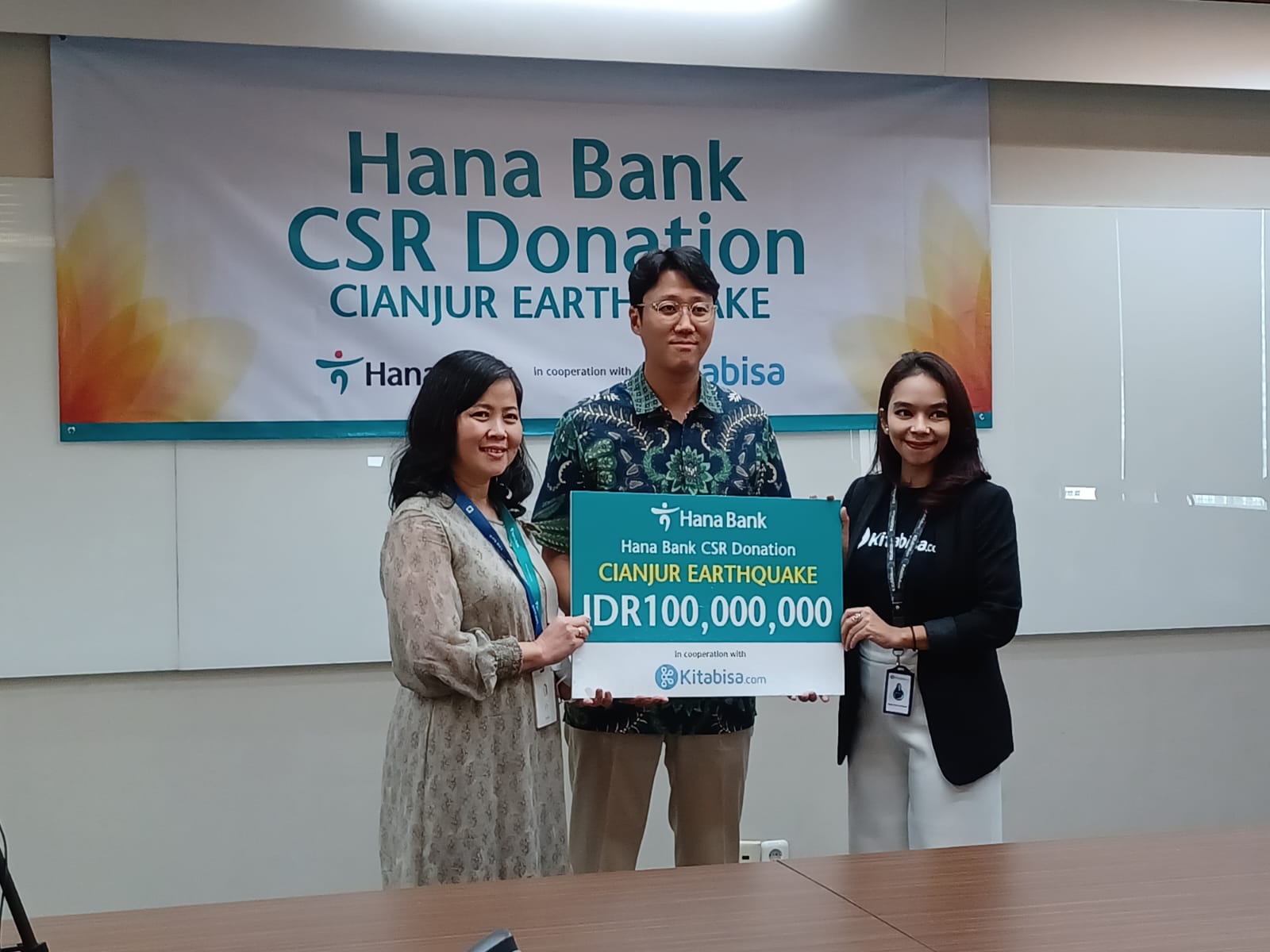 Chief of Human Capital & Operations Bank Hana, Sumia (kiri) dan Strategy Planning Head, Bank Hana, Lim Seong Dong (tengah) menyerahkan donasi secara simbolis kepada Head of Brand Partnership Kitabisa.com, Marisa Thara Wardani (kanan). dok. ist. Bank Hana Serahkan Bantuan Kemanusiaan untuk Korban Gempa Cianjur