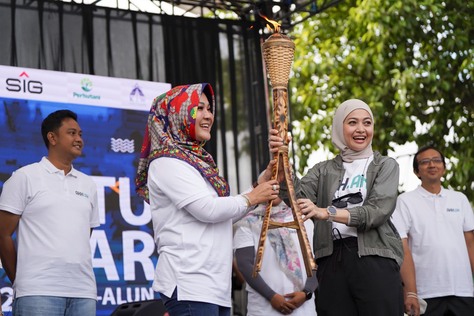 Corporate Secretary SIG Vita Mahreyni (kedua kanan) menyerahkan obor estafet kepada Bupati Klaten Sri Mulyani (kedua kiri) saat membuka acara Jalan Sehat Bersama BUMN 2023 di alun-alun Klaten, Jawa Tengah, Sabtu (4/3/2023). dok. ist. Rayakan HUT ke-25 Kementerian BUMN, SIG dan Anak Usaha Ajak Masyarakat Jalan Sehat