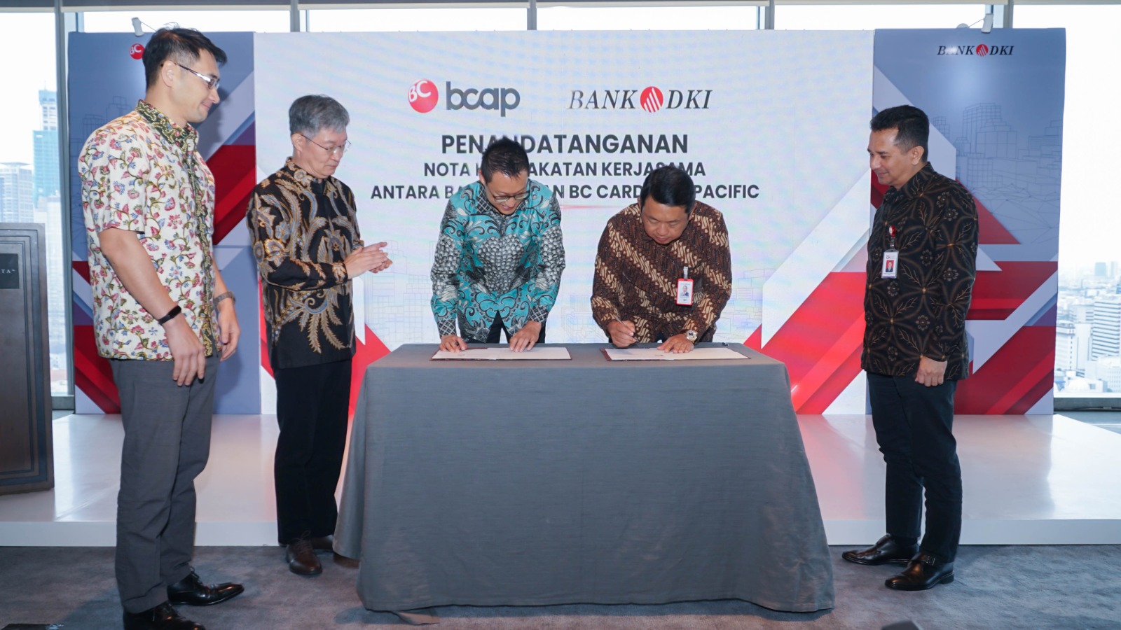 Direktur Teknologi dan Operasional Bank DKI, Amirul Wicaksono (tengah-kanan) dan CEO BC Card Asia Pacific, Hong Seok Man (tengah-kiri) melakukan penandatanganan Nota Kesepakatan antara PT Bank DKI dan BC Card Asia Pacific, tentang penyediaan sistem dan layanan Acquiring bagi nasabah Bank DKI, disaksikan oleh CEO MJL, Myoung Jun Lee (paling kiri), CEO BC Card Korea, Choi Wonseok (kiri kedua), serta Kepala Otoritas Jasa Keuangan Regional 1 DKI Jakarta & Banten, Roberto Akyuwen (kanan) di Jakarta , Senin (7/3/2023). dok. ist.. Akselerasi Bisnis Pembayaran Digital, Bank DKI Gandeng BC Card Asia Pacific