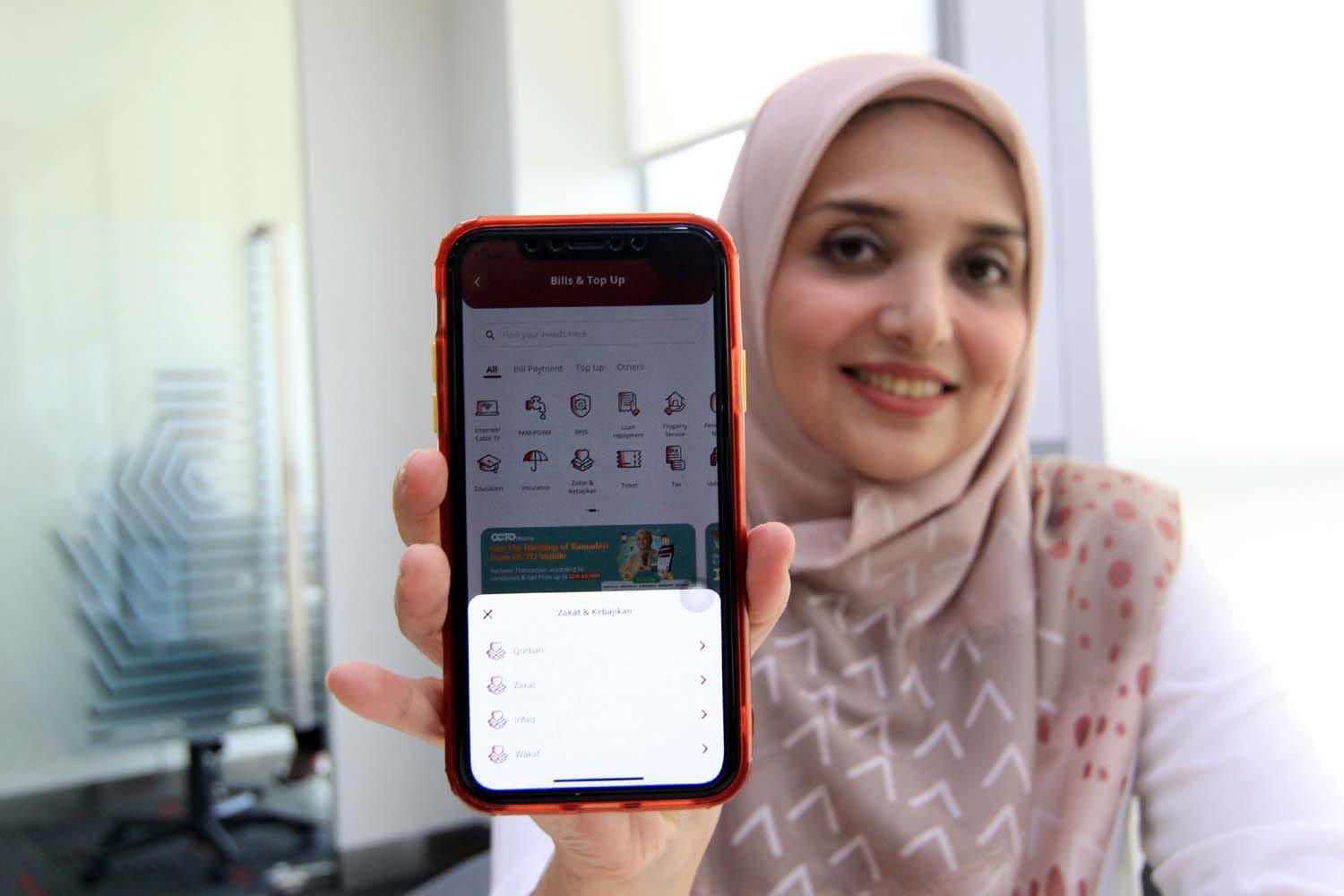 Nasabah melakukan pembayaran zakat menggunakan Super App OCTO Mobile di Jakarta, Senin (3/4/2023). Di bulan Ramadan 1444 Hijriah ini, CIMB Niaga Syariah mengoptimalkan fitur pembayaran Zakat dan Kebajikan dari OCTO Mobile. dok. ist. CIMB Niaga Syariah Fasilitasi Bayar Zakat Pakai OCTO Mobile