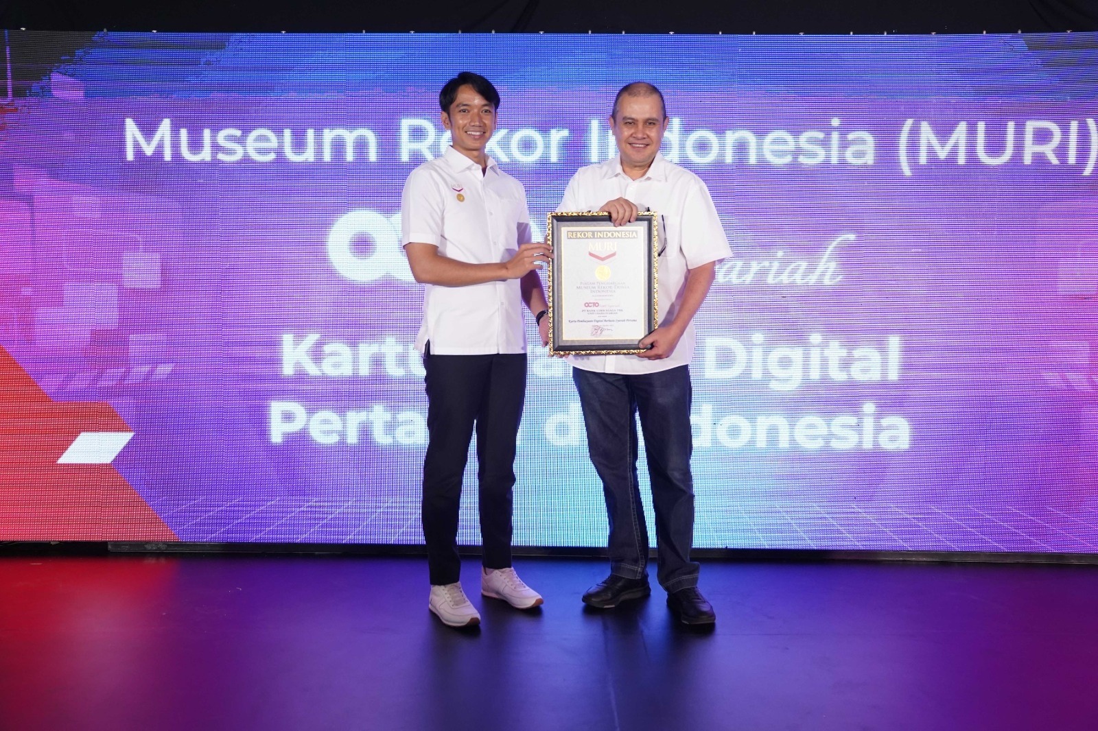 Direktur Syariah Banking CIMB Niaga Pandji P. Djajanegara (kanan) menerima Penghargaan dari Museum Rekor Dunia Indonesia (MURI) untuk CIMB Niaga Syariah sebagai bank pertama di industri perbankan syariah yang meluncurkan produk kartu syariah digital (tanpa kartu fisik). Penghargaan diberikan oleh Senior Manager MURI Triyono dalam acara Peluncuran OCTO Card Syariah di Jakarta, Kamis (19/10/2023). dok. ist. Luncurkan OCTO Card Syariah, CIMB Niaga Syariah dapat Penghargaan dari MURI
