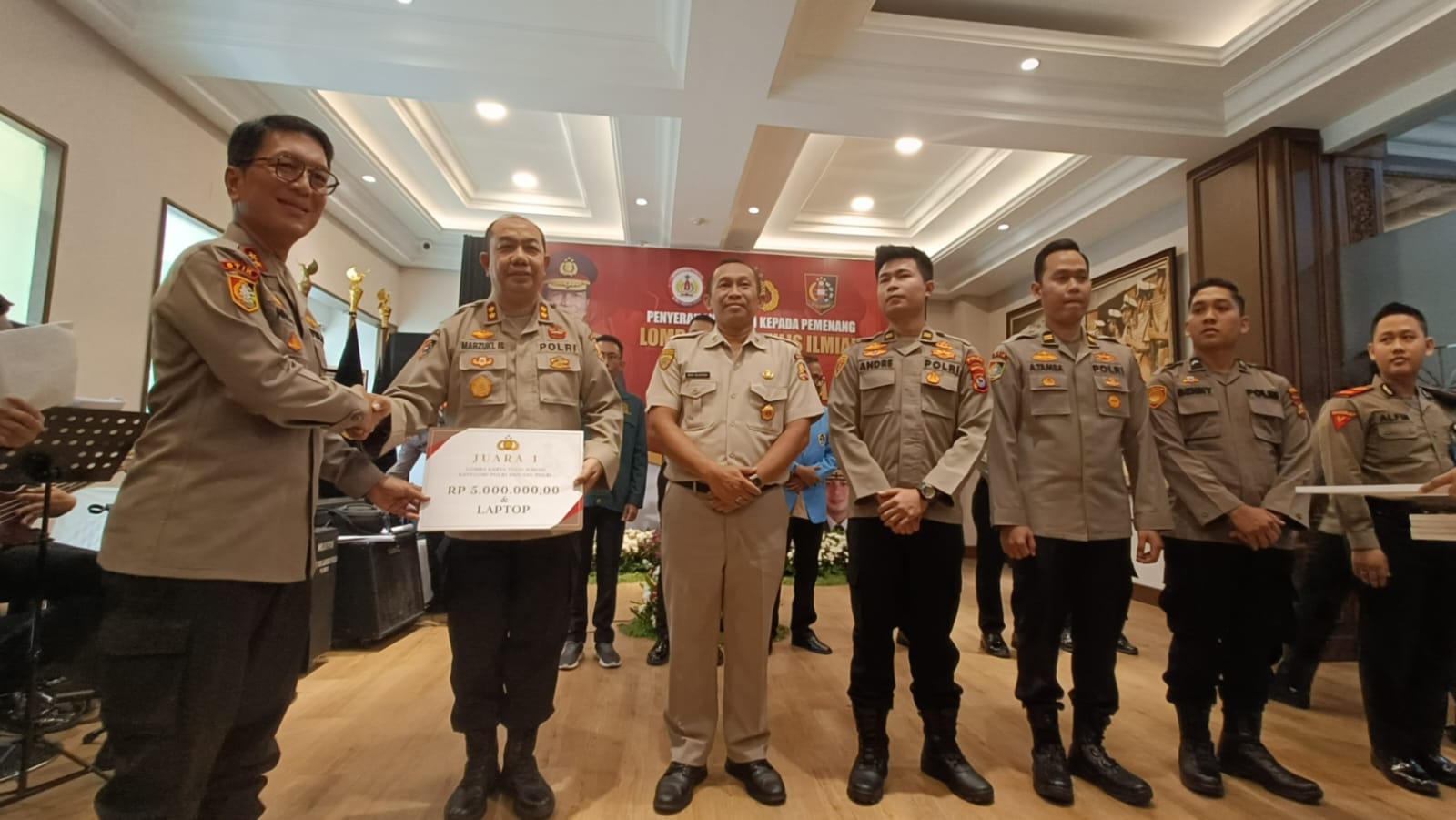 Kepala STIK Lemdiklat Polri Irjen Pol Dr. Nico Afinta, S.I.K., S.H. , M.H. saat menyerahkan hadiah kepada pemenang Lomba Karya Tulis Ilmiah STIK Lemdiklat Polri kategori Polri, AKBP Marzuki Ismail (kedua kiri) di Gedung STIK Lemdiklat Polri, Jakarta, pada Kamis (26/10/2023). dok. ist. Hari Sarjana Indonesia 2023, BCA Dukung Lomba Karya Tulis Ilmiah STIK Lemdiklat Polri