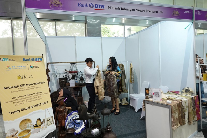 Seorang pembeli sedang mencoba produk dari Atico Ecoprint, Usaha Mikro Kecil dan Menengah (UMKM) yang dibina PT Bank Tabungan Negara (Persero) Tbk, di acara Natal Bersama Kementerian BUMN di Jakarta, Senin (16/1). KUR Bank BTN (BBTN) Melesat 195 Persen di 2023