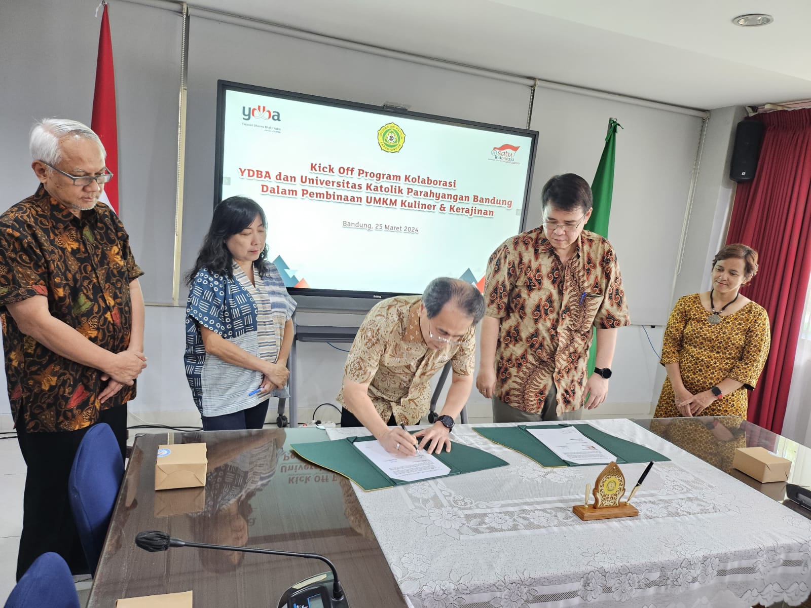 Penandatanganan Perjanjian Kerjasama Pembinaan UMKM Kuliner & Kerajinan di Bandung antara Astra melalui Yayasan Dharma Bhakti Astra (YDBA) yang diwakili oleh Ketua Pengurus YDBA, Sigit P. Kumala (tengah); Sekretaris Pengurus YDBA, Ema Poedjiwati Prasetio (kedua kiri) dan Universitas Katolik Parahyangan (UNPAR) yang diwakili oleh Kepala Lembaga Penelitian dan Pengabdian Kepada Masyarakat UNPAR, Prof. J. Dharma Lesmana (kedua kanan) dan disaksikan oleh Advisor YDBA, Tonny Sumartono (kiri) dan Wakil Rektor Bidang Kerjasama, Alumni, Inovasi, dan Bisnis UNPAR, Ir. Catharina Badra Nawangpalupi, Ph.D. (kanan), Senin (25/3/2024). dok. ist. Astra Melalui YDBA - Unpar Jalin Kerja Sama Bina UMKM Naik Kelas