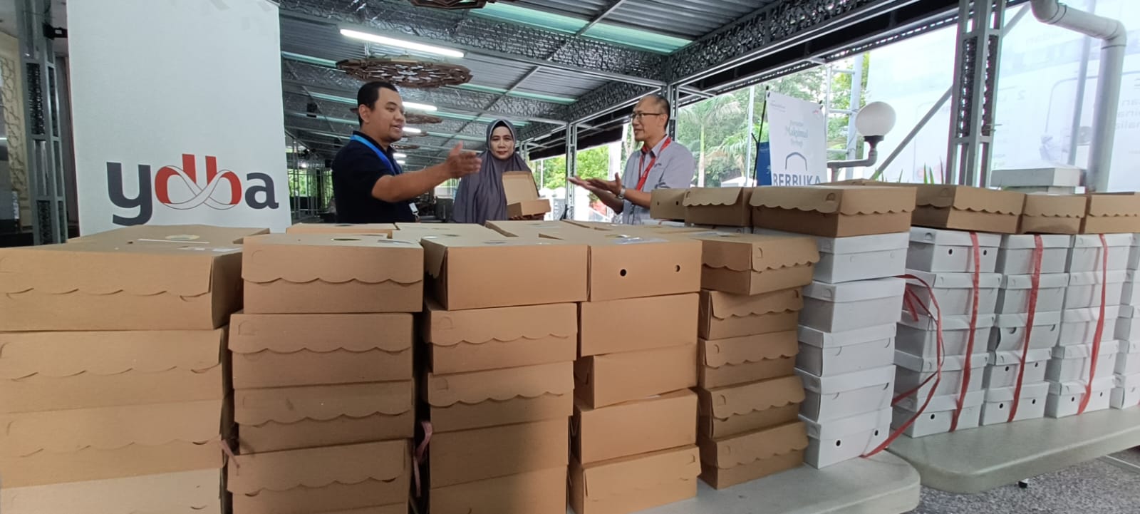 UMKM Kuliner binaan Lembaga Pengembangan Bisnis (LPB) Cakung yang didirikan Astra melalui Yayasan Dharma Bhakti Astra (YDBA) dan PT United Tractors Tbk.(UTD), Zubaidah Isnani (tengah) menunjukkan produk kulinernya kepada Head of Communication & Information System YDBA, Rahmat Handoyo (kanan) dan Kepala Divisi Administrasi & Keuangan YAA, Rahmat Hidayat (kiri) di Masjid Astra, Jakarta, Senin (1/4/2024). dok. ist. Kolaborasi YDBA-YAA Fasilitasi UMKM Kuliner Binaan Pasok Menu Berbuka