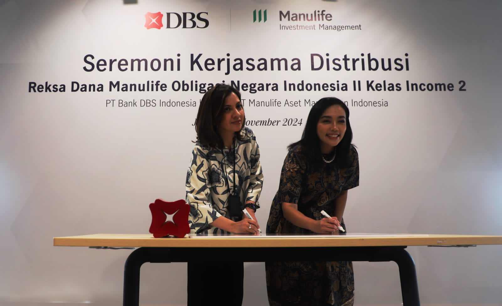 (Kiri-Kanan): Consumer Banking Director PT Bank DBS Indonesia Melfrida Gultom bersama CEO & President Director PT Manulife Aset Manajemen Indonesia (MAMI) Afifa, menandatangani kerja sama distribusi reksa dana Manulife Obligasi Negara Indonesia II Kelas Income 2 (MONI II Kelas Income 2), di Jakarta, Kamis (21/11/2024). Nasabah Bank DBS Indonesia kini dapat melakukan transaksi pembelian reksa dana MONI II Kelas Income 2 yang memiliki fitur dividen yang relatif stabil dan dapat diprediksi melalui digibank by DBS. Dok. Ist. Distribusi Reksa Dana MONI II Kelas Income 2, Bank DBS Kolaborasi MAMI