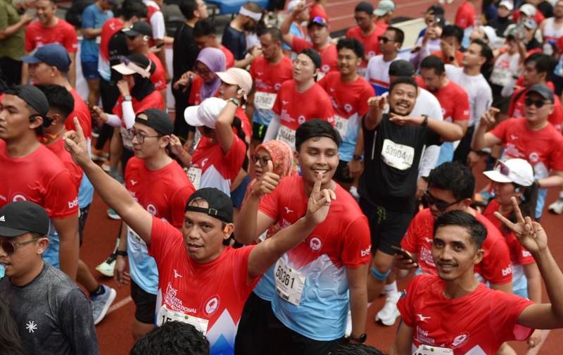 Direktur Utama BTN Nixon LP Napitupulu, mengangkat dua tangan di tengah kerumunan peserta yang turun diikuti oleh 52 negara. (Foto: Endang Muchtar) BTN JAKIM 2025 Sukses! Jalan Sudirman-Thamrin Dipenuhi Lautan Manusia