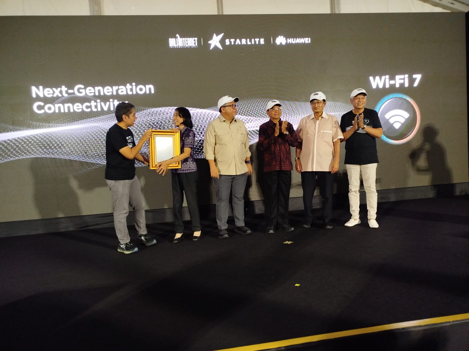 Kiri-Kanan: Yune Marketatmo, Presiden Direktur PT Solusi Sinergi Digital Tbk (WIFI) atau Surge memberikan plakat kepada Kepala Sekolah SMPN 15 Denpasar, disaksikan oleh Wamen Perumahan dan Kawasan Pemukiman RI, Gubernur Bali Wayan Koster, shareholder Surge Fadel Muhammad dan Arwin Rasyid. Photo/Rizki Emitennews.com SURGE, Bali Internet, dan Huawei Hadirkan Wi-Fi 7 Pertama di Indonesia