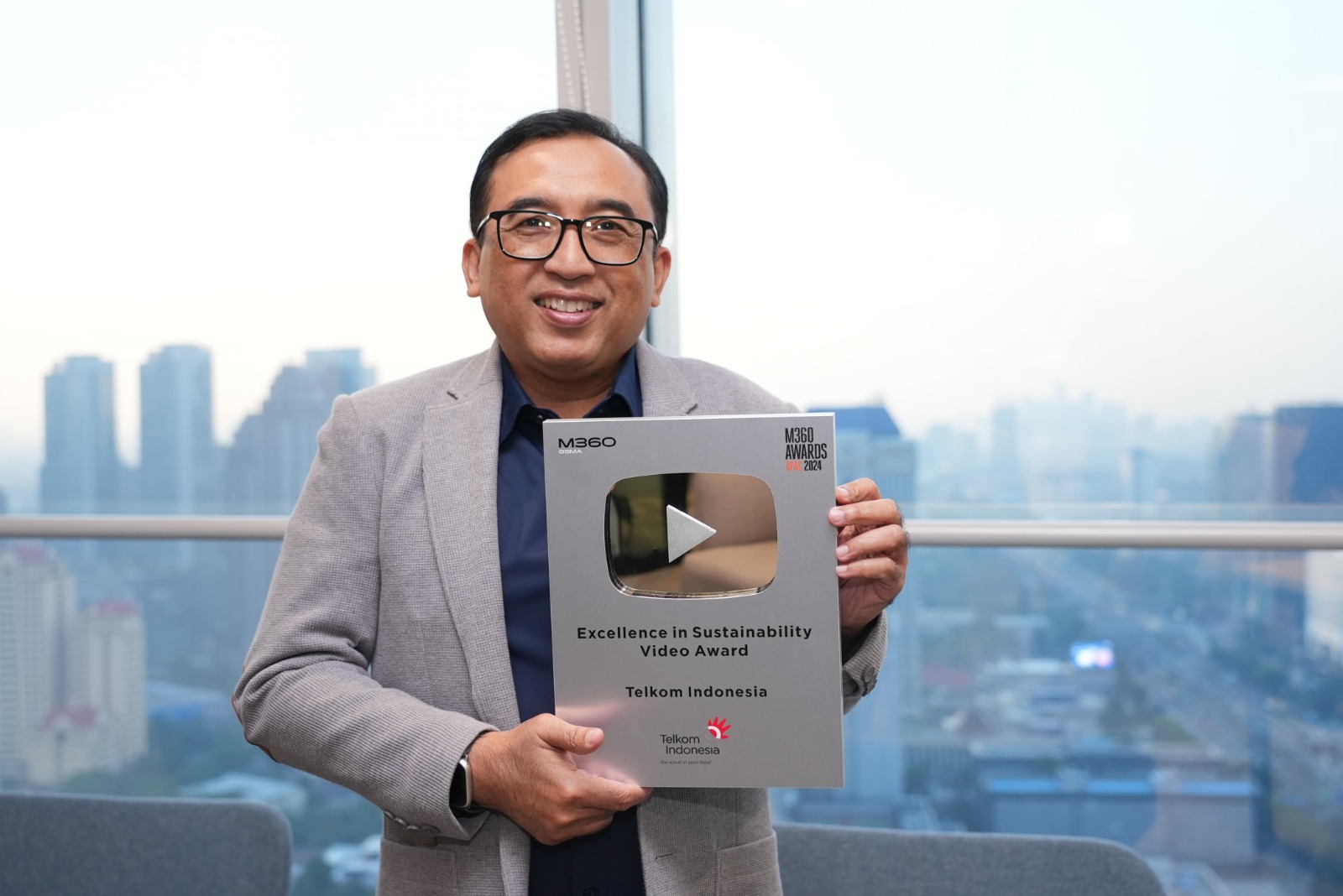 VP Corporate Communication Telkom Andri Herawan Sasoko menunjukkan trofi M360 Digital Nations Awards 2024. Melalui video “Water Management System: Constructing a Sustainable Tomorrow”, Telkom memenangkan kategori Excellence in Sustainability Video Award. Dok. Telkom. GSMA M360 Digital Nations Awards 2024, Penghargaan Dunia untuk Telkom